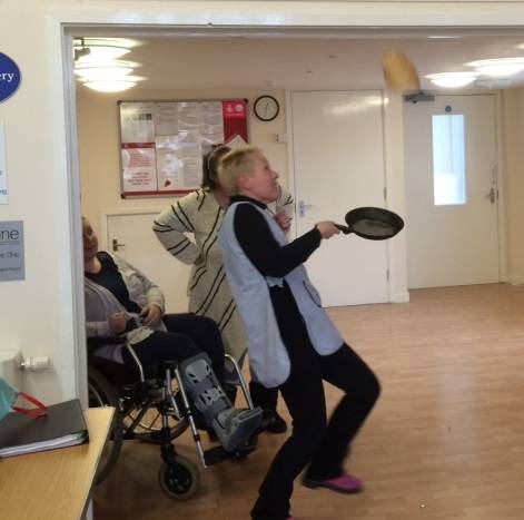 Bev flipping a pancake and attempting to catch it back in the frying pan.