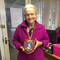 Dee, dressed in purple, holding the town plaque.